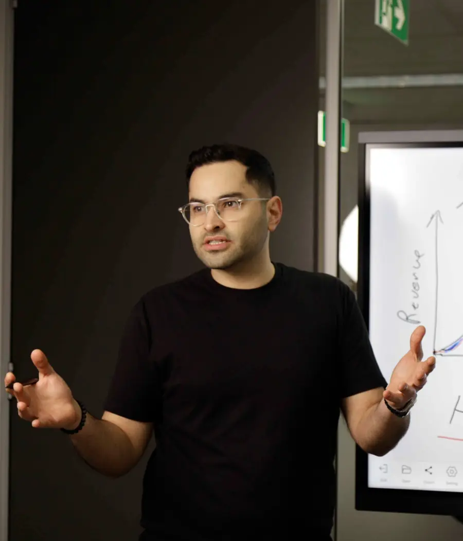 Armin Hashemi explaining how to scale a business on a whiteboard