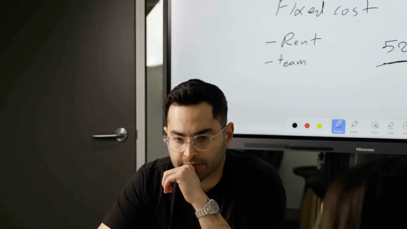 Armin Hashemi reviewing a business's fixed costs in a meeting